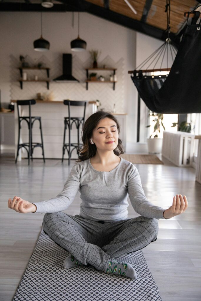 A young woman meditates peacefully indoors, reflecting the support of best mind therapists for stress, anxiety, and clinical depression.